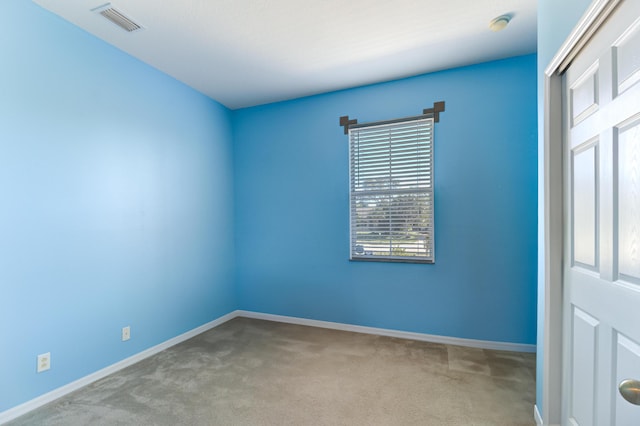 spare room with a wealth of natural light and light colored carpet