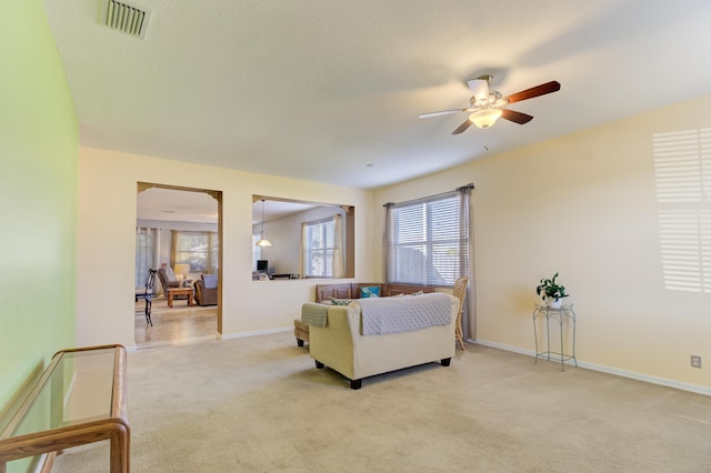 carpeted living room featuring ceiling fan