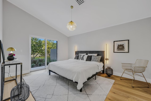 bedroom featuring vaulted ceiling, hardwood / wood-style floors, and access to outside