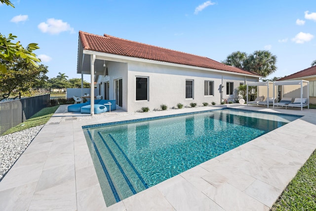 back of property with a patio and a fenced in pool