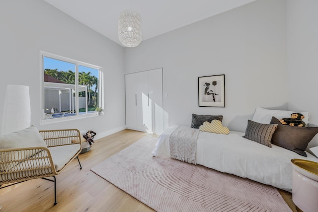 bedroom featuring light hardwood / wood-style floors and a chandelier