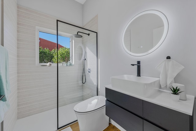 bathroom featuring tiled shower, vanity, and toilet