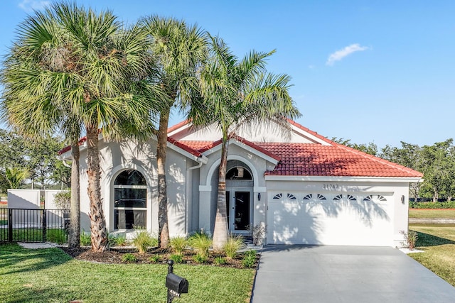 mediterranean / spanish-style home with a front yard and a garage