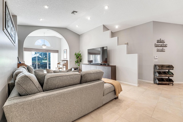 living room with ceiling fan, plenty of natural light, a textured ceiling, and high vaulted ceiling