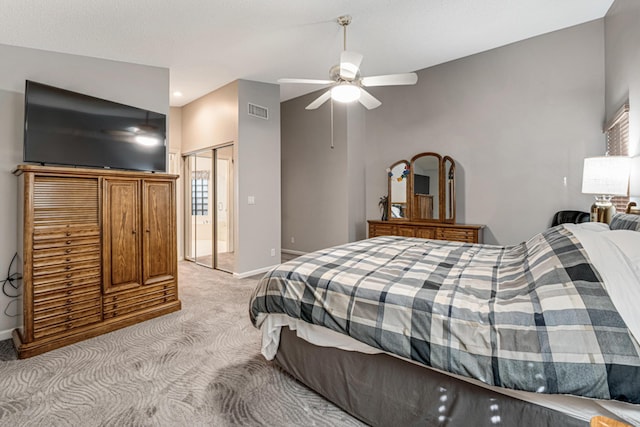 bedroom featuring light carpet, ceiling fan, a closet, and lofted ceiling