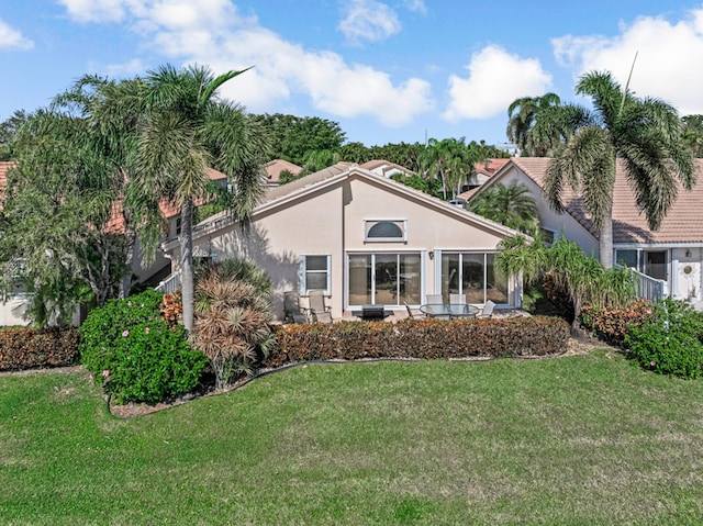 rear view of house featuring a lawn