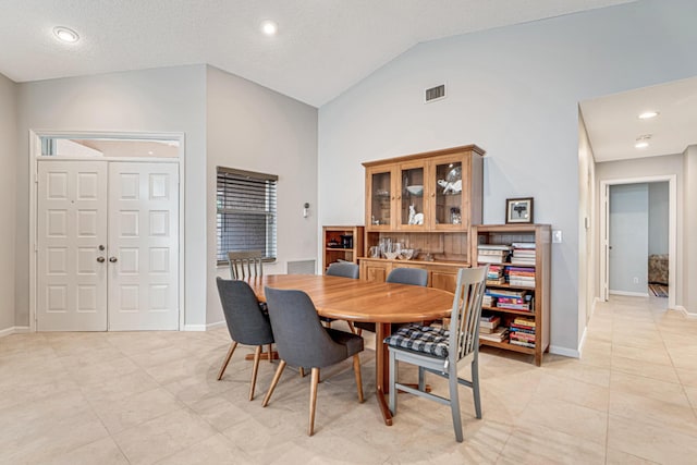 tiled dining room with high vaulted ceiling