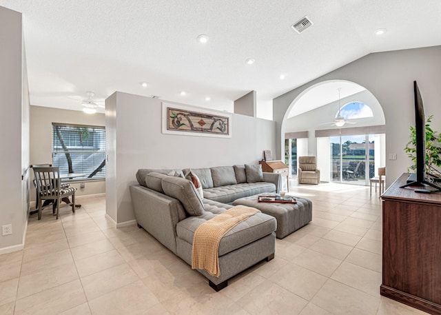 tiled living room featuring ceiling fan, a textured ceiling, and lofted ceiling