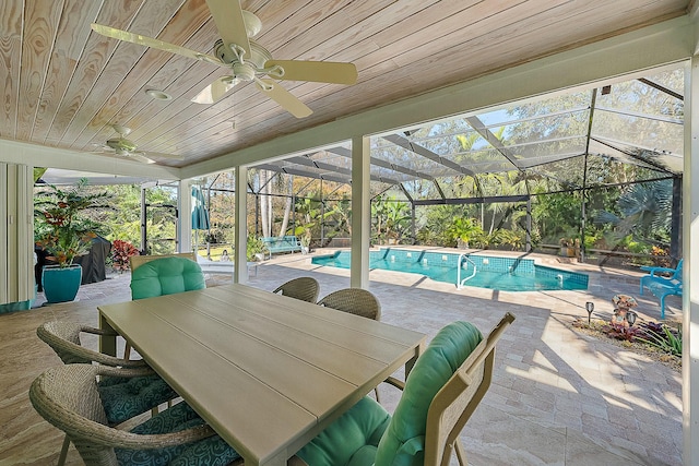 view of swimming pool featuring ceiling fan, a patio, and glass enclosure