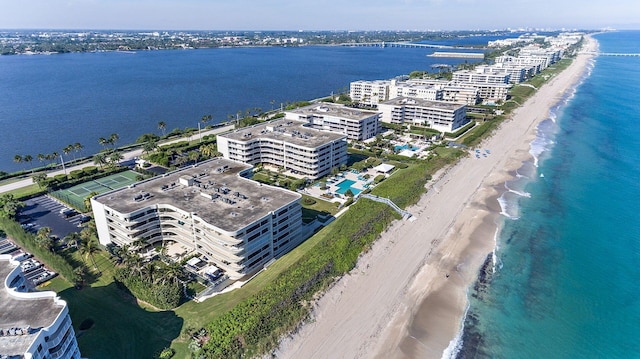 birds eye view of property featuring a water view and a beach view