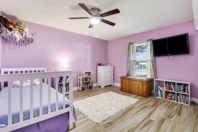 bedroom featuring ceiling fan with notable chandelier and hardwood / wood-style floors