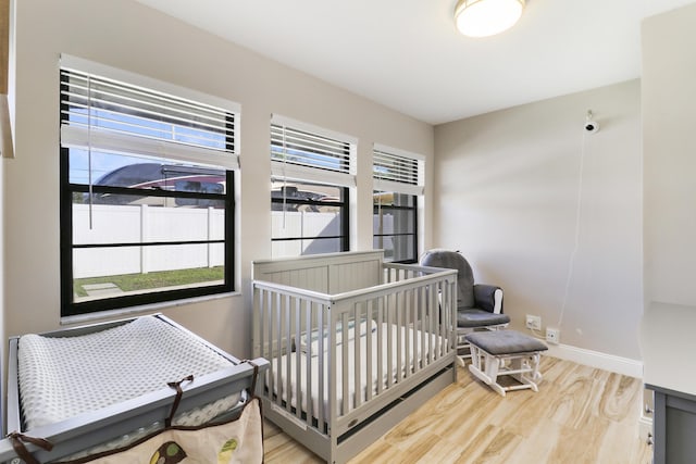 bedroom featuring a crib and hardwood / wood-style floors