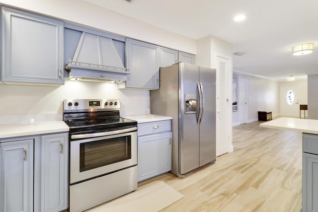 kitchen featuring gray cabinets, stainless steel appliances, light hardwood / wood-style floors, and premium range hood