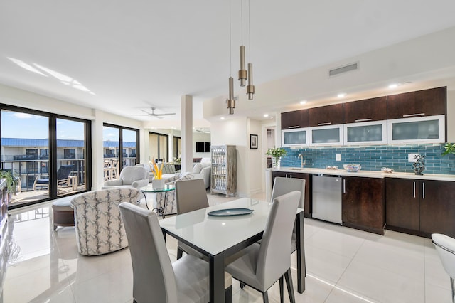 dining area featuring sink, light tile patterned floors, and ceiling fan