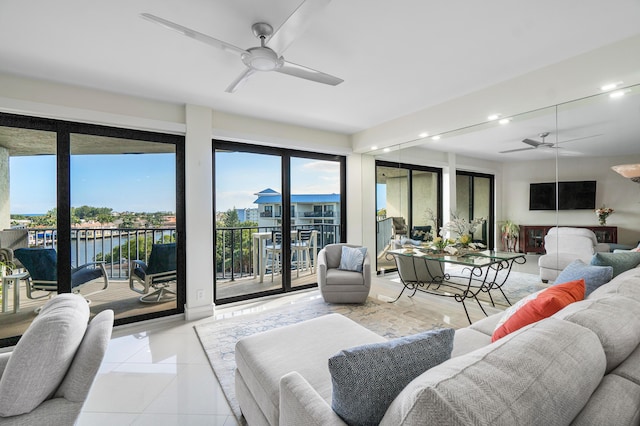 living room with a water view, light tile patterned floors, and ceiling fan