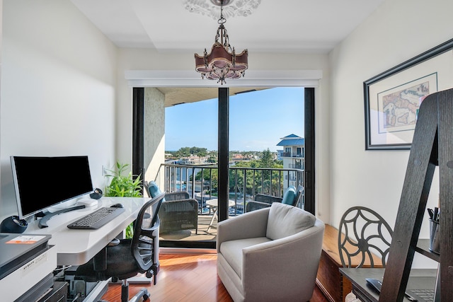 office space with a healthy amount of sunlight, a chandelier, and hardwood / wood-style floors