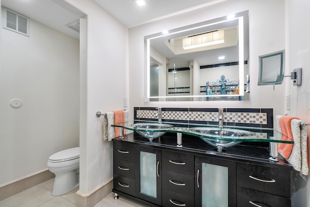 bathroom with tile patterned flooring, vanity, backsplash, and toilet