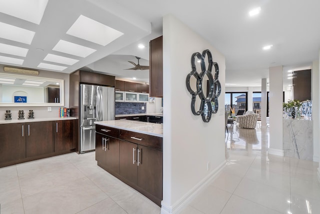 kitchen with stainless steel fridge with ice dispenser, backsplash, dark brown cabinets, and light tile patterned floors