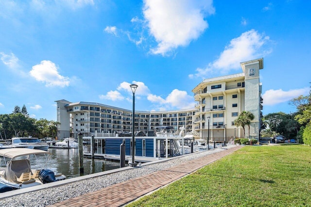 view of dock with a yard and a water view