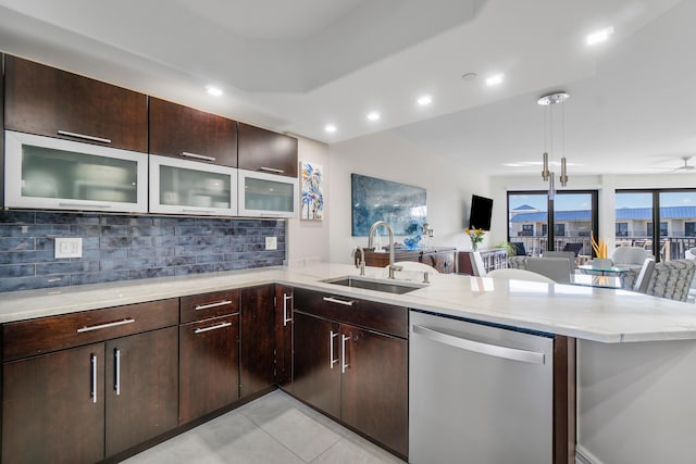 kitchen with sink, backsplash, stainless steel dishwasher, light tile patterned floors, and kitchen peninsula