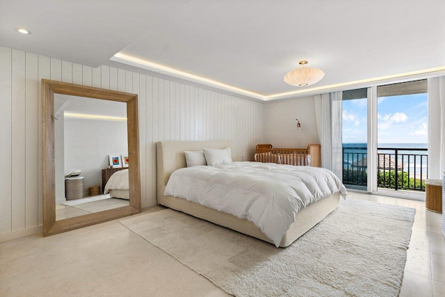 bedroom featuring floor to ceiling windows, access to exterior, and a water view