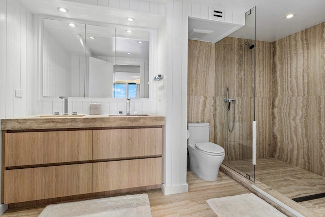 bathroom with toilet, hardwood / wood-style floors, walk in shower, vanity, and wood walls