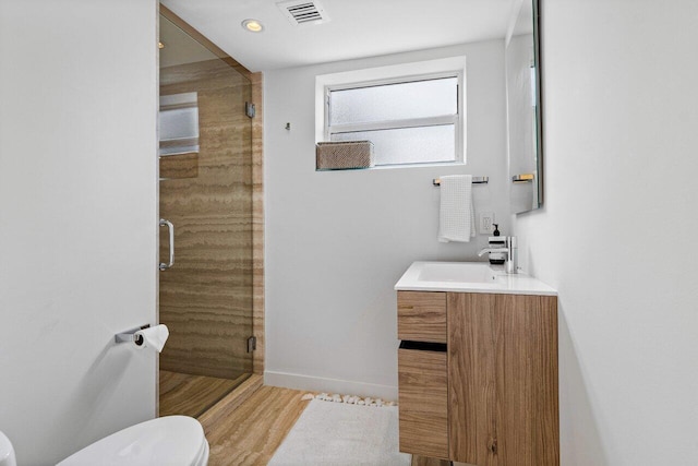 bathroom featuring vanity, toilet, a shower with door, and hardwood / wood-style flooring