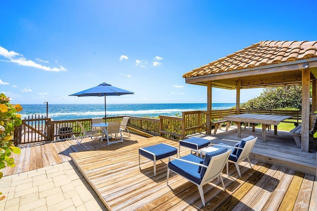 wooden deck featuring a water view and a gazebo