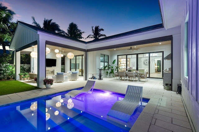 view of patio featuring outdoor dining space, a ceiling fan, and an outdoor pool