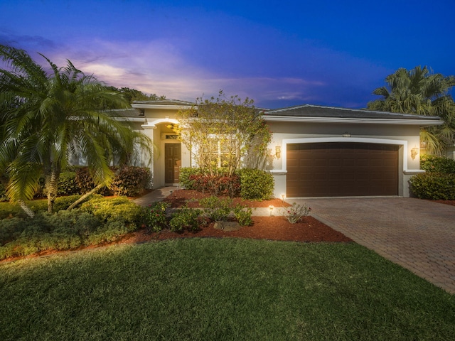 view of front of home featuring a garage and a lawn