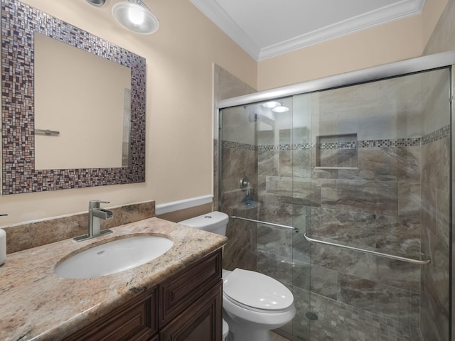 bathroom with crown molding, toilet, a shower with shower door, and vanity