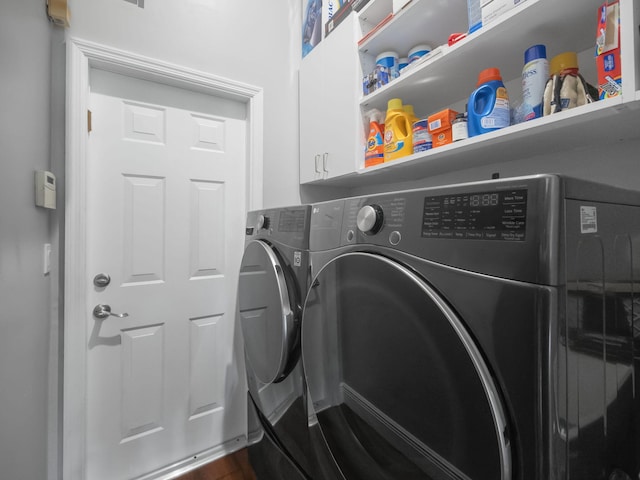 washroom featuring cabinets and washing machine and dryer