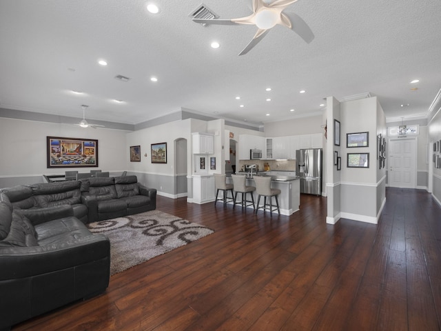 living room with ceiling fan, dark wood-type flooring, and a textured ceiling