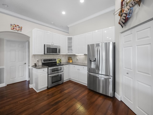 kitchen featuring dark stone counters, white cabinetry, appliances with stainless steel finishes, and tasteful backsplash