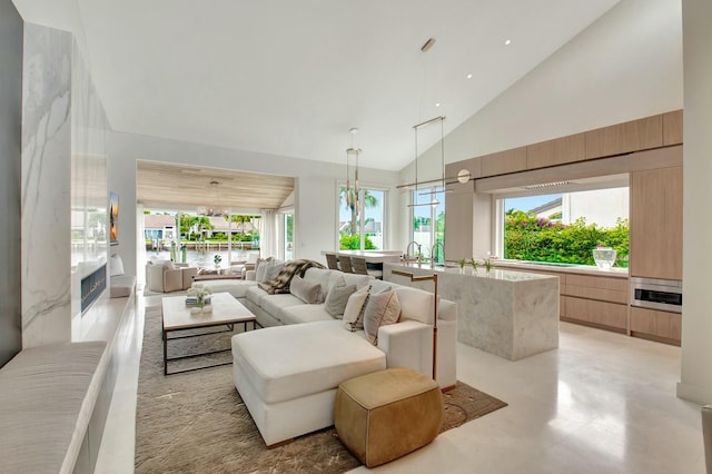 living room with high vaulted ceiling and a water view