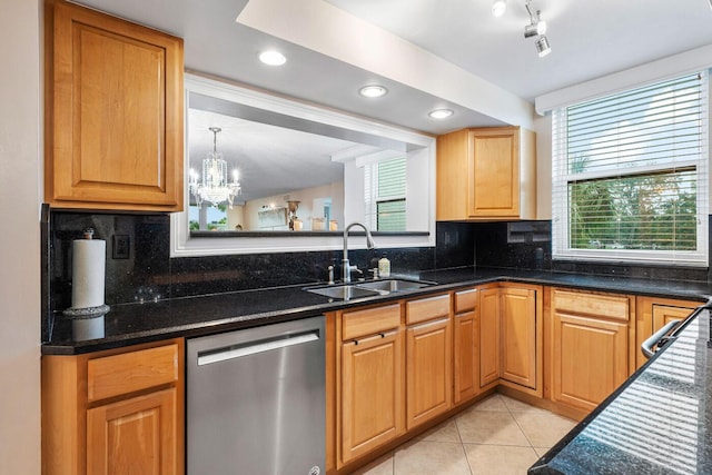 kitchen with decorative light fixtures, stainless steel dishwasher, decorative backsplash, sink, and light tile patterned flooring