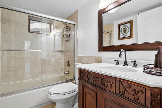 full bathroom with toilet, vanity, tile walls, and shower / bath combination with glass door