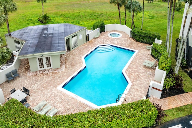 view of swimming pool featuring french doors, a patio area, a hot tub, and a yard