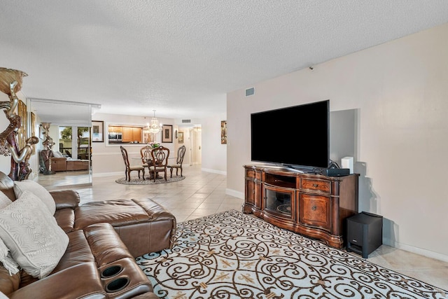 living room featuring a textured ceiling, light tile patterned floors, and an inviting chandelier