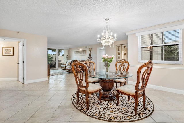 tiled dining room featuring a textured ceiling and an inviting chandelier