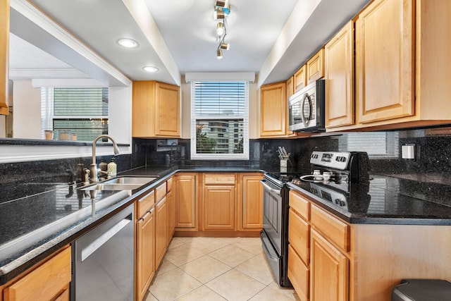 kitchen with decorative backsplash, light tile patterned flooring, sink, stainless steel appliances, and rail lighting