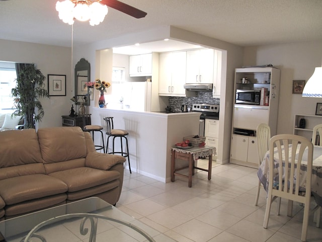 tiled living room featuring ceiling fan and a textured ceiling