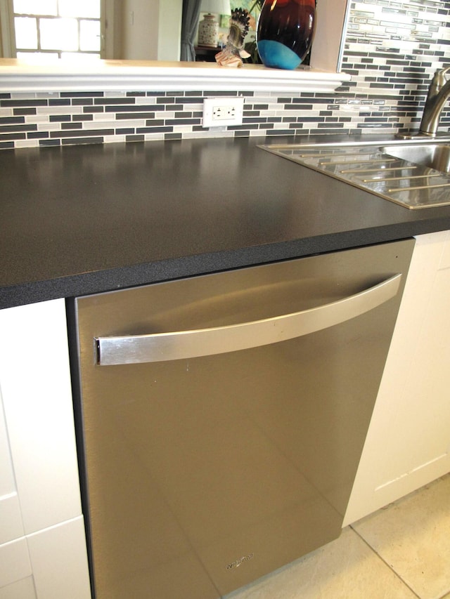 room details featuring sink, white cabinetry, dishwasher, and backsplash