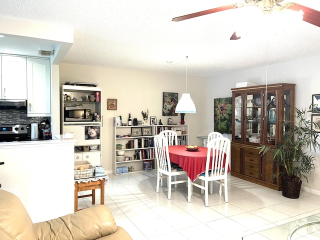 dining space with a textured ceiling, ceiling fan, and light tile patterned floors