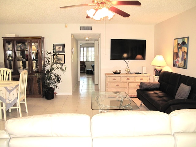 tiled living room featuring a textured ceiling and ceiling fan