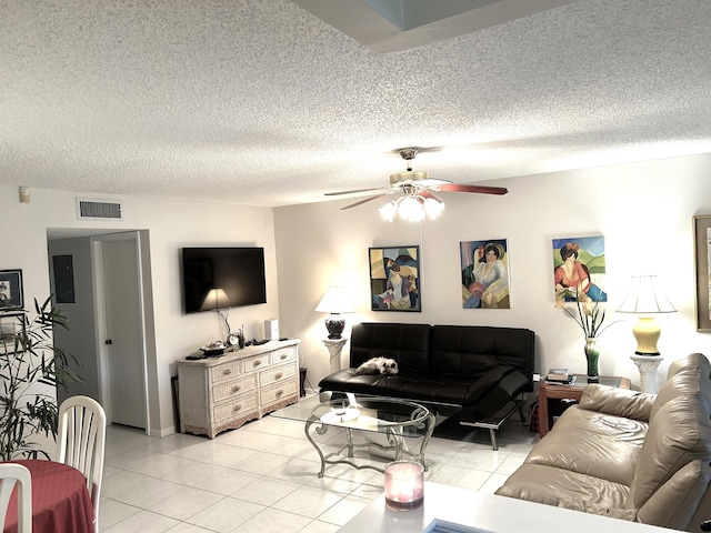 tiled living room featuring a textured ceiling, ceiling fan, and electric panel