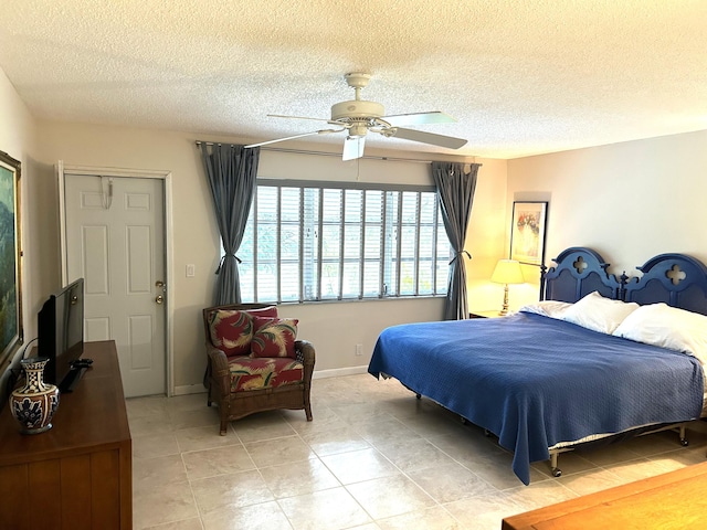 bedroom with ceiling fan, a closet, light tile patterned flooring, and a textured ceiling