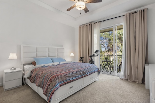 carpeted bedroom with access to outside, a raised ceiling, and ceiling fan