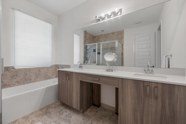 bathroom featuring a healthy amount of sunlight, independent shower and bath, and vanity