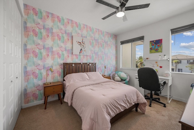 carpeted bedroom featuring ceiling fan and a closet